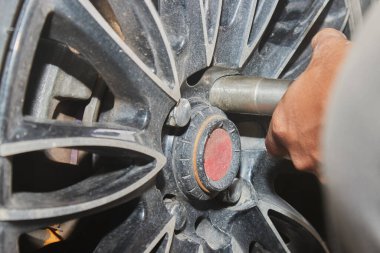Car Mechanic Tighten Magnesium Wheel Nut by Wind Block on Center Frame