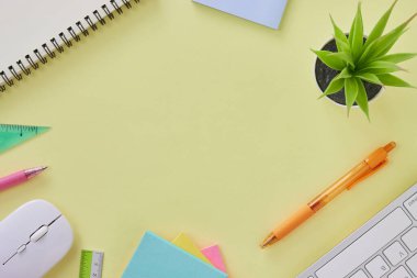 Flat Lay veya Top View Modern Office Masası veya Klavye, Pen, Stick Note, Cetvel, Fare, Not Defteri, Ofis Bitkileri olarak Kırtasiye Masası. Sarı Minimalist Çalışma Alanı Arkaplanı