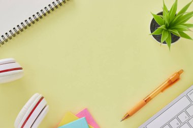 Top View ya da Flat Lay Modern Office Masası ya da Klavye, Kalem, Not Defteri, Not Defteri, Ofis Bitkileri olarak Kırtasiye Masası. Sarı Minimalist Çalışma Alanı Arkaplanı