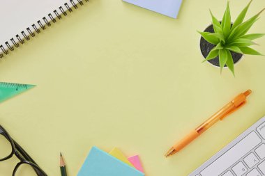 Top View ya da Flat Lay Modern Ofis Masası ya da Klavye, Kalem, Kalem, Cetvel, Cetvel, Not Defteri, Ofis Bitkileri olarak Kırtasiye Masası. Sarı Minimalist Çalışma Alanı Arkaplanı