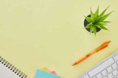 Top View ya da Flat Lay Modern Office Table ya da Office Desk as Klavye, Pen, Stick Note, Notebook, Office Plants. Sarı Minimalist Çalışma Alanı Arkaplanı