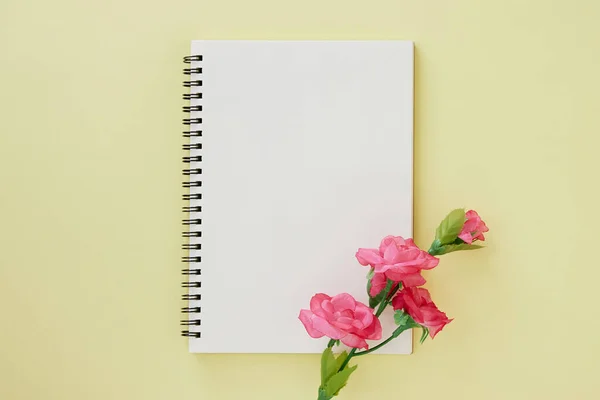 スパイラルノートや春のノートブックは アウトライン型とパステルイエローミニマリストの背景にバラの花 スパイラルノート Mock Center Frame — ストック写真