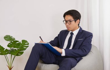 Asyalı Mali Danışman İç İşleri Ofisinde Gözlük Yazısı Bildirisi Giyiyor. İşadamı Sosyal Mesafe İçin Evde Çalışıyor veya Covid 19 'da Ev Karantinası veya Coronavirüs Durumu