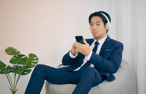 Ασιατικός Οικονομικός Σύμβουλος Φορέστε Ακουστικά Και Touch Smartphone Στο Home — Φωτογραφία Αρχείου