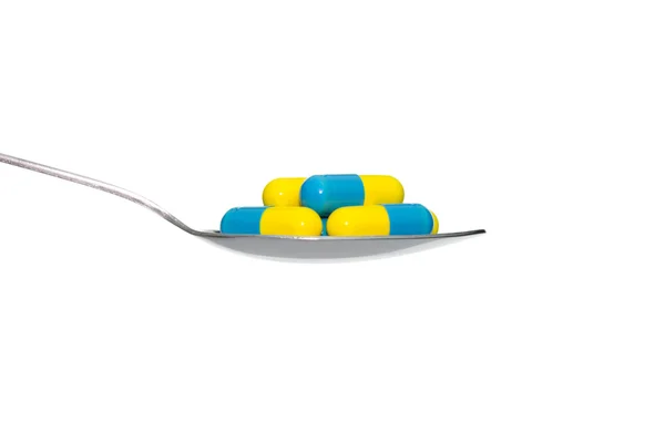 Blue Yellow Medicine or Capsule on Spoon Isolated on White Backg — Stock Photo, Image