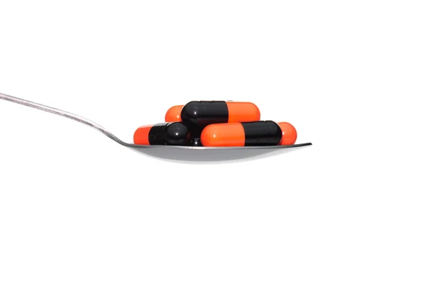 Black Orange Medicine or Capsule on Spoon Isolated on White Back — Stock Photo, Image