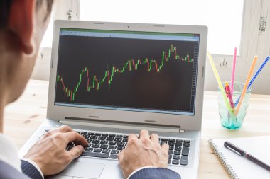 İşadamı analiz hisse senedi grafiği veya dizüstü bilgisayar tarafından Forex grafik