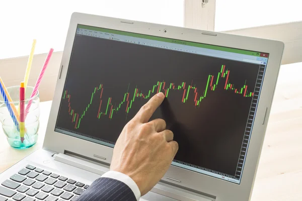 İşadamı noktası ve Forex grafik veya hisse senedi grafiği sağ parmak tarafından analiz