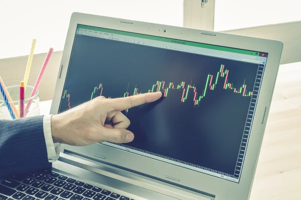 İşadamı noktası ve Forex grafik veya hisse senedi grafik mavi Vintage tarzı üzerinde analiz
