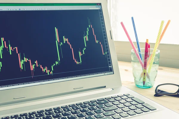 Stock or Forex Graph in Laptop Screen on Left View on Blue Vintage Style — Stock Photo, Image