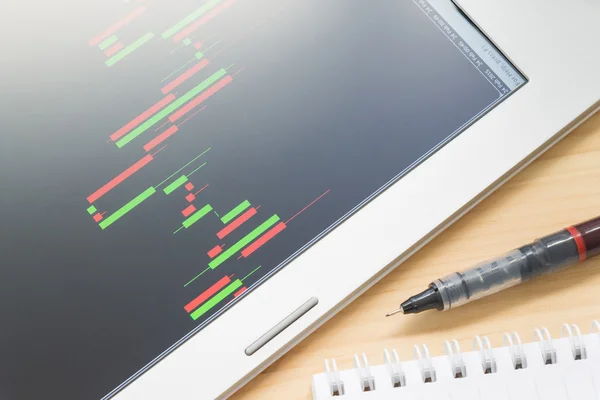 Hisse senedi veya Forex grafik veya mum grafiği Tablet ekran ve kalem ve defter