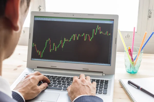 Geschäftsmann analysiert Aktiendiagramm oder Devisendiagramm per Laptop — Stockfoto