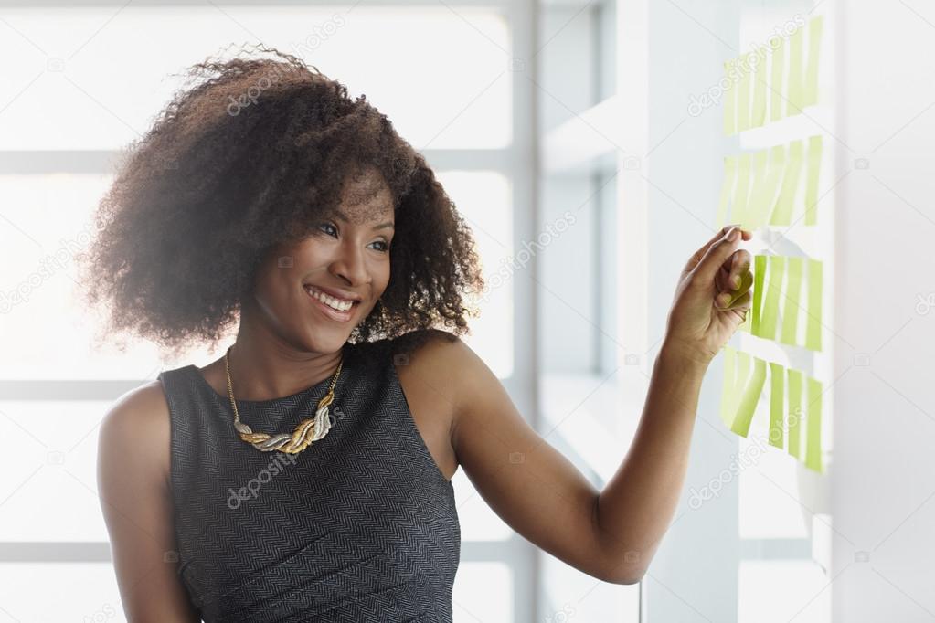 Portrait of a smiling business woman with an afro in bright glass office