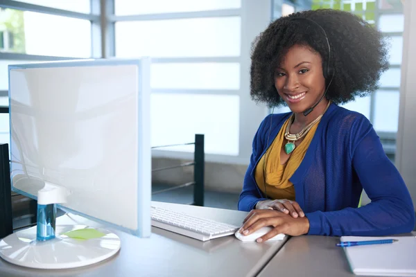 Portret van een lachende medewerker van de klantenservice met een afro op de computer gebruik van de hoofdtelefoon — Stockfoto