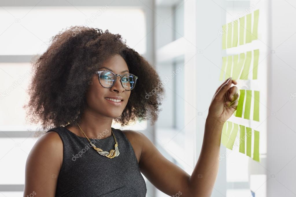 Portrait of a smiling business woman with an afro in bright glass office