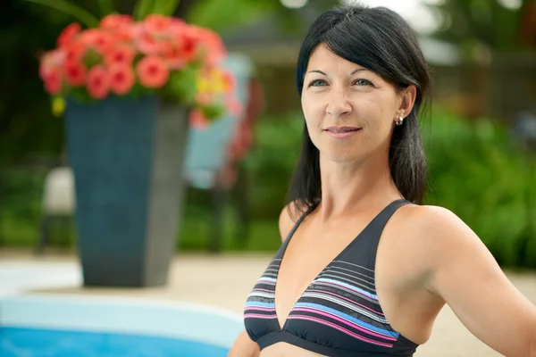 Mujer madura nadando en una piscina de agua azul —  Fotos de Stock