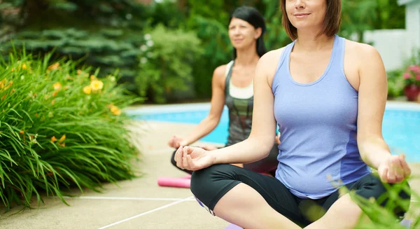 Dua wanita dewasa tetap fit dengan melakukan yoga di musim panas — Stok Foto