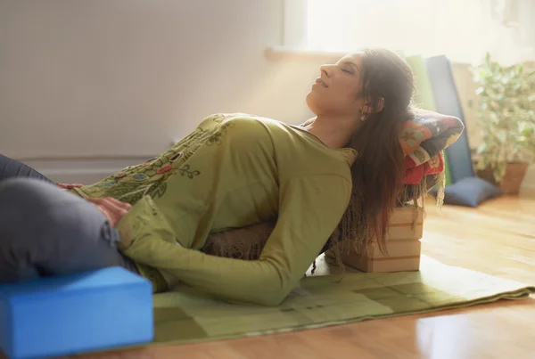 Attraktive Mischlingsfrau macht restauratives Yoga — Stockfoto
