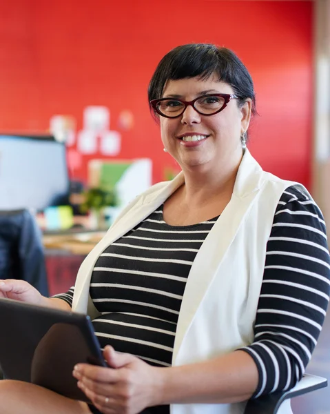 Dijital tablet kırmızı yaratıcı ofis alanı içinde çalışan kendine güvenen kadın tasarımcı — Stok fotoğraf