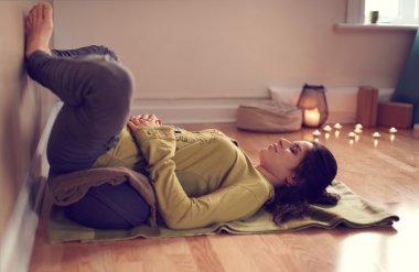 Attractive mixed race woman doing restorative yoga clipart
