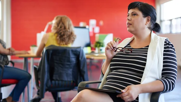 Selbstbewusste Designerin arbeitet im roten Kreativbüro an einem digitalen Tablet — Stockfoto