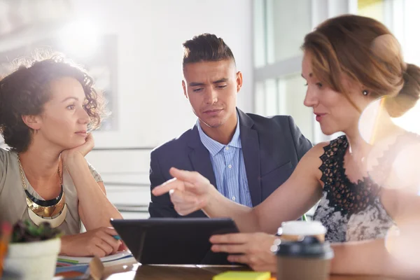 Imagen de tres personas de negocios exitosas usando una tableta durante la reunión — Foto de Stock