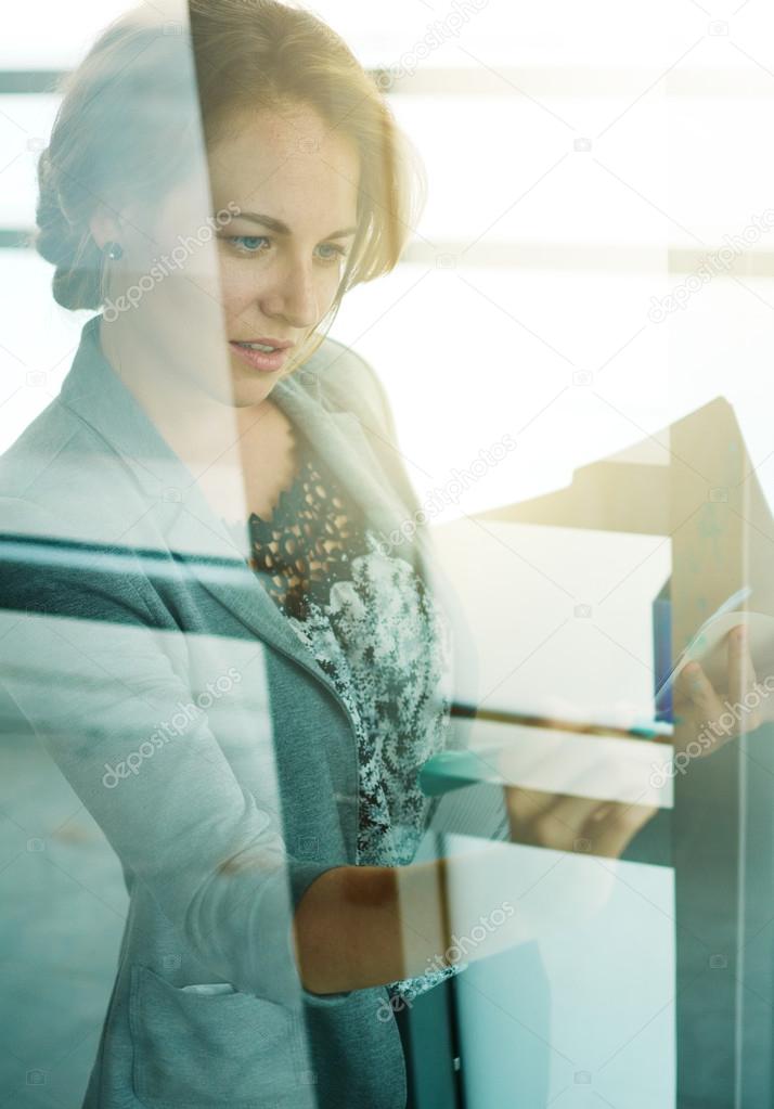 Filtered portrait of an executive business woman writing on a glass wall at sunset