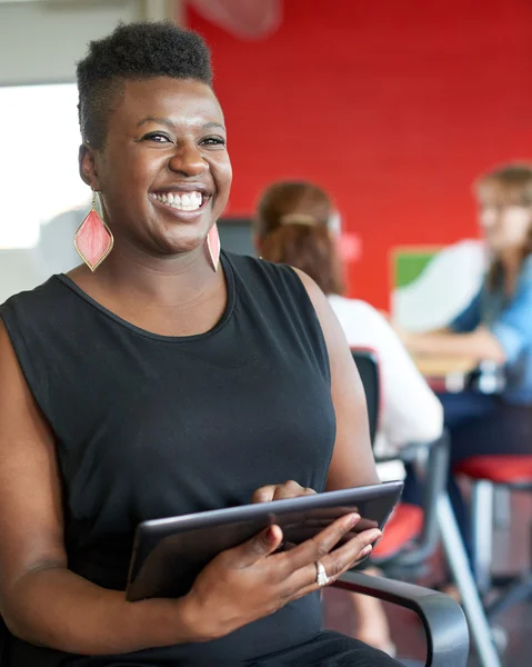 Conceptrice confiante travaillant sur une tablette numérique dans un espace de bureau créatif rouge — Photo