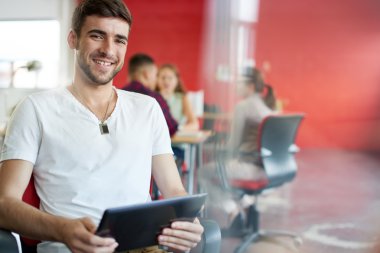 Dijital tablet kırmızı yaratıcı ofis alanı içinde çalışan kendine güvenen erkek tasarımcı