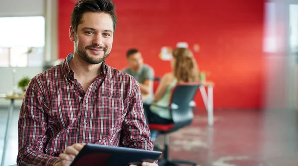 Designer masculino confiante trabalhando em um tablet digital no espaço de escritório criativo vermelho — Fotografia de Stock