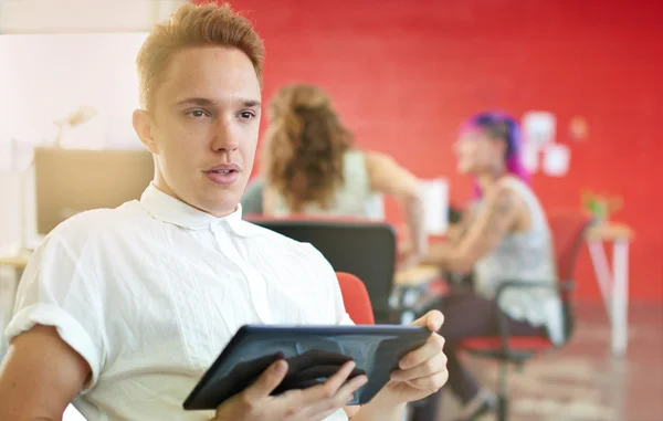 Dijital tablet kırmızı yaratıcı ofis alanı içinde çalışan kendine güvenen erkek tasarımcı — Stok fotoğraf