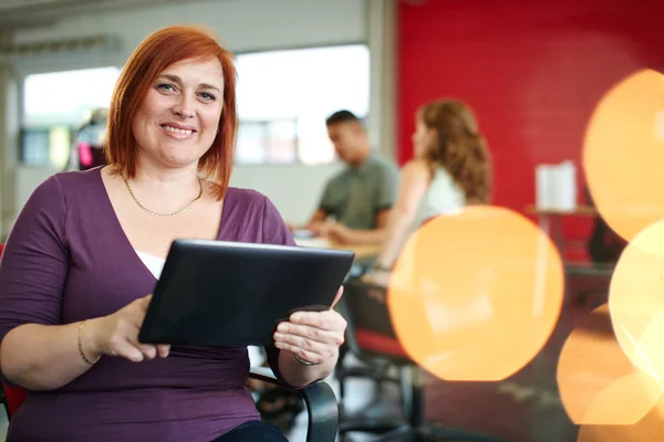 Designer feminina confiante trabalhando em um tablet digital no espaço de escritório criativo vermelho — Fotografia de Stock