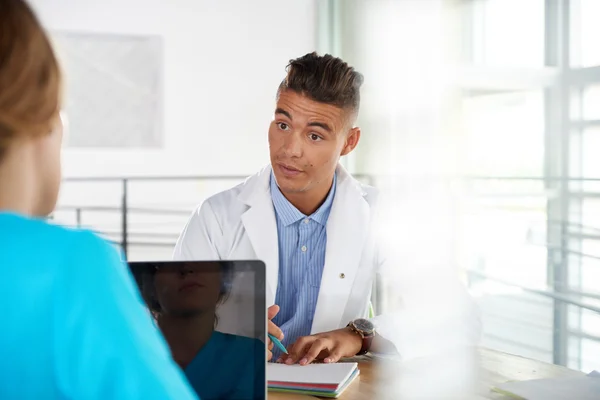 Doktor ve hemşire parlak modern ofis masasında oturan bir hasta tanı tartışırken ekibi — Stok fotoğraf