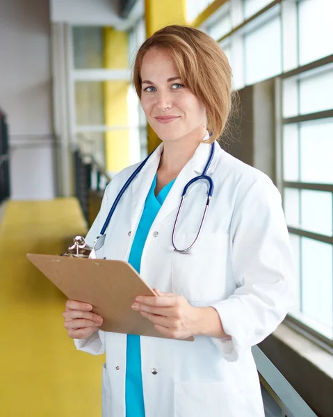 Portret van een vrouwelijke arts houden van haar patiënt grafiek in heldere moderne ziekenhuis — Stockfoto