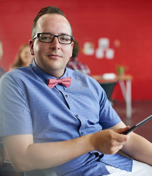 Diseñador masculino confiable trabajando en una tableta digital en el espacio de oficina creativo rojo — Foto de Stock