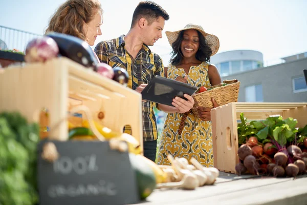 Vriendelijke vrouw neigt een biologische plantaardige kraam op een boerenmarkt en verkopen verse groenten uit de tuin op het dak — Stockfoto