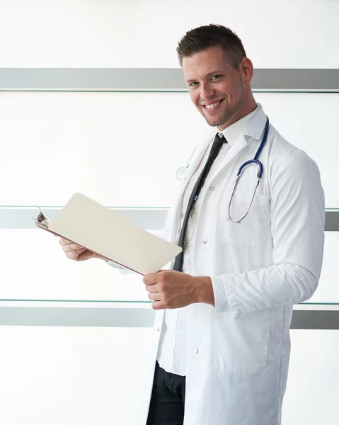 Portret van een mannelijke arts zijn patiënt grafiek houden in heldere moderne ziekenhuis — Stockfoto