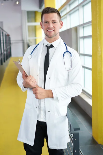 一位男医生在明亮的现代医院拿他耐心的图表的肖像 — 图库照片