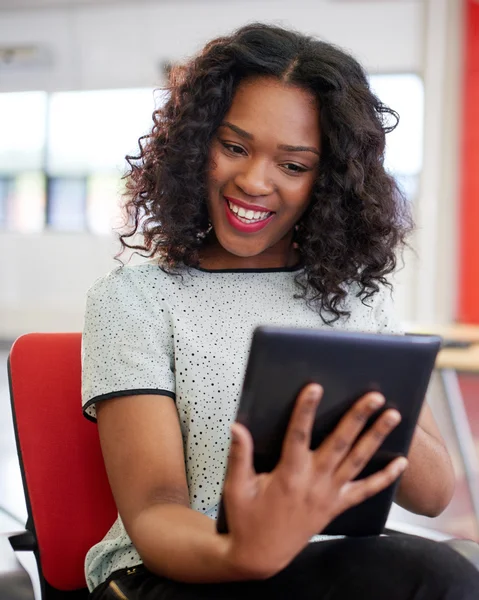 Vertrouwen vrouwelijke ontwerper werkt aan een digitaal tablet in rode creatieve kantoorruimte — Stockfoto