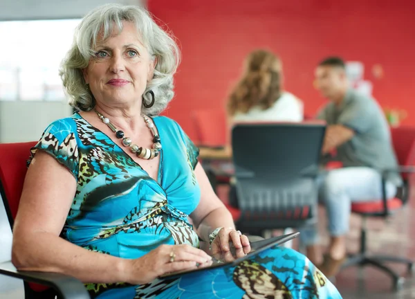 Dijital tablet kırmızı yaratıcı ofis alanı içinde çalışan kendine güvenen kadın tasarımcı