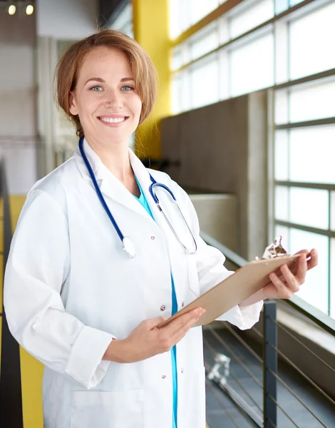 Retrato de una doctora sosteniendo su historia clínica en un hospital moderno y luminoso —  Fotos de Stock