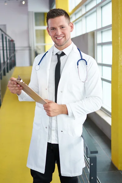 밝은 현대 병원에서 그의 환자 차트를 들고 남성 의사의 초상화 — 스톡 사진