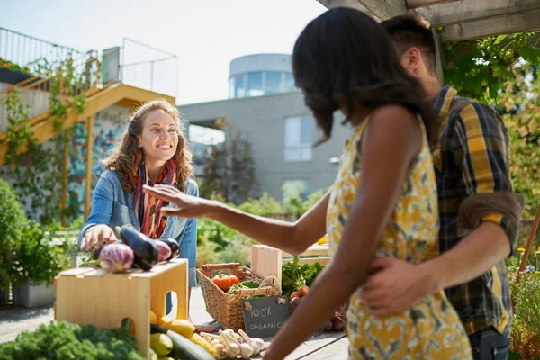 Freundliche Frau, die auf einem Bauernmarkt einen Bio-Gemüsestand pflegt und frisches Gemüse aus dem Dachgarten verkauft — Stockfoto