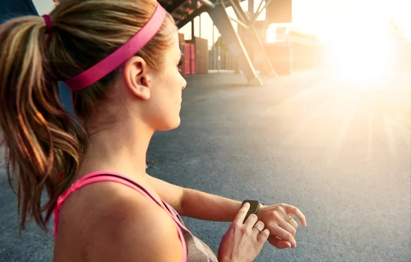 Kvinnan programmering hennes smartwatch innan kommer jogging att spåra prestanda — Stockfoto