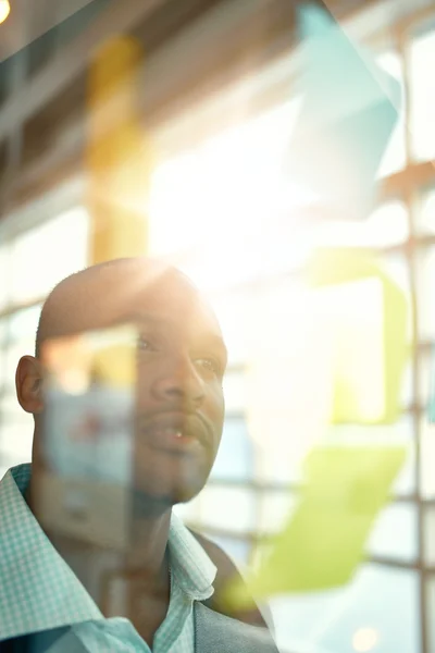 Zwei kreative Kleinunternehmer aus der Jahrtausendwende, die an einem Social-Media-Brainstorming mithilfe von Klebezetteln in Fenstern arbeiten — Stockfoto