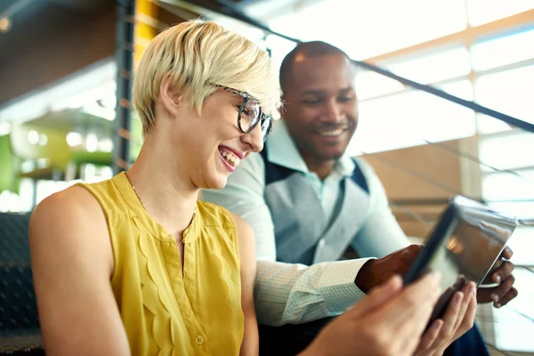 Dos propietarios de pequeñas empresas milenarias creativas que trabajan en la estrategia de redes sociales utilizando una tableta digital mientras están sentados en la escalera — Foto de Stock