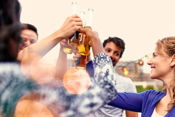 Grupo multi-étnico milenar de amigos festejando e desfrutando de uma cerveja no terraço do último piso ao pôr do sol — Fotografia de Stock