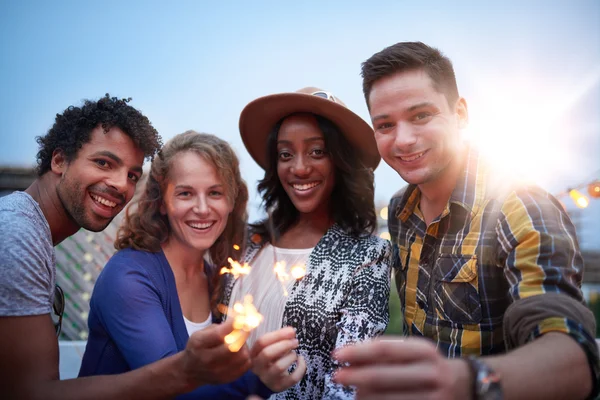 Groupe millénaire multi-ethnique d'amis pliantscintillements sur le toit-terrasse au coucher du soleil — Photo