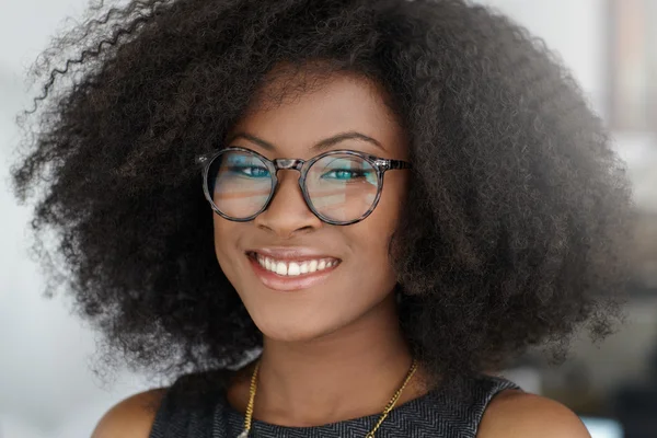 Ritratto di una donna d'affari sorridente con un afro in un luminoso ufficio di vetro — Foto Stock