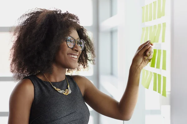 Portrait of a smiling business woman with an afro in bright glass office — Stock Photo, Image